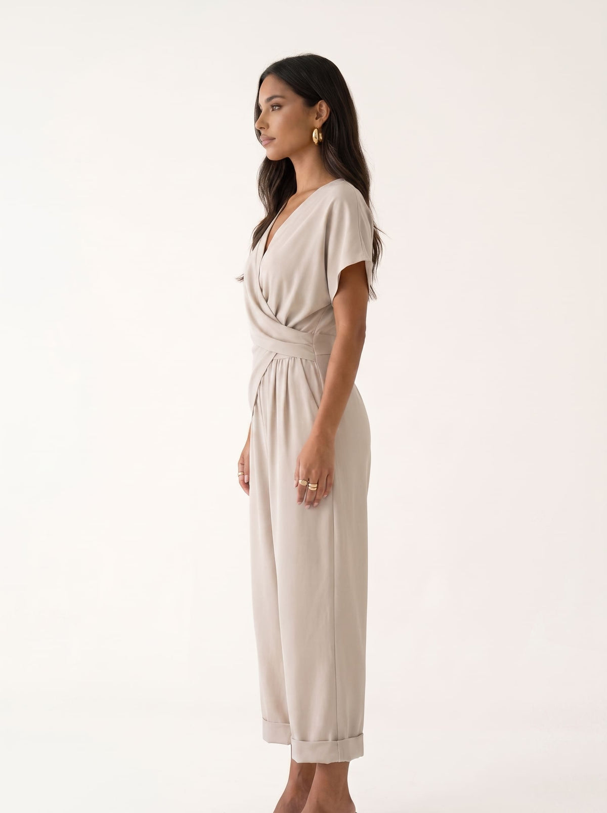 Mujer usando mono beige con perlas, estilo elegante y veraniego, por Liria Studio en la edición verano azul.